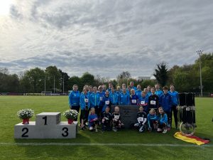 Gruppenbild: Die Einradgemeinschaft Münster neben dem Siegertreppchen