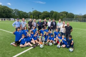 Gruppenbild: Spieler SC Sprakel sitzen auf neuem Kunstrasenplatz