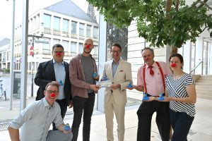 Gruppenbild: Mitglieder des Round Table überreichen Los fürs Entenrennen