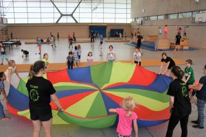 Bewegte Kids: Kinder mit buntem Tuch in Turnhalle